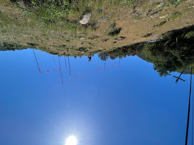 Installer working on story poles with sun above